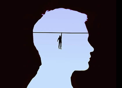 Illustration of figure hanging from tightrope inside man's head